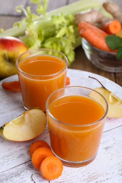 Glas juice med äpple och morot på träbord nära håll — Stockfoto