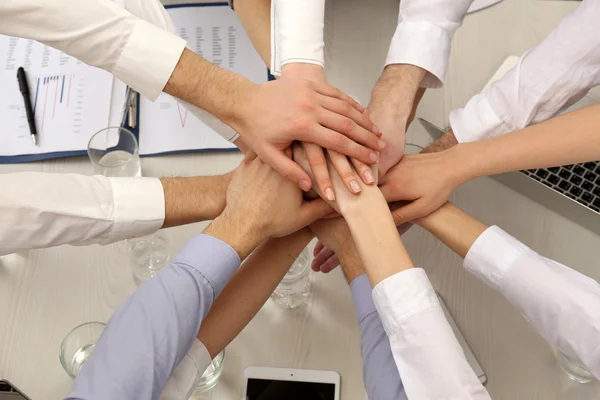 United hands of business team on workspace background top view — Stock Photo, Image