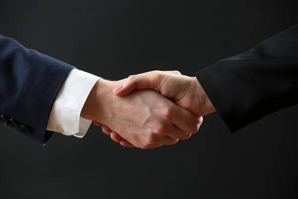 Business handshake on dark background — Stock Photo, Image