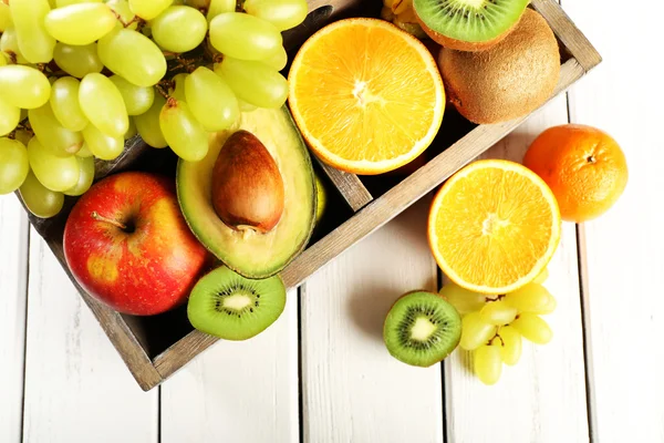 Assortiment van vruchten in vak op houten tafel — Stockfoto