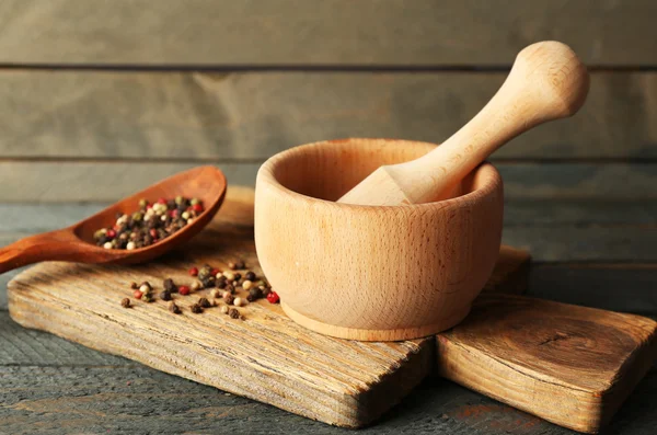 Mezcla de pimientos en mortero sobre fondo de madera — Foto de Stock