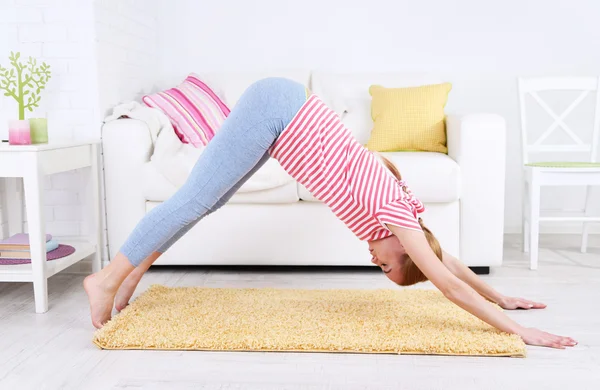 Mujer joven haciendo yoga en casa —  Fotos de Stock