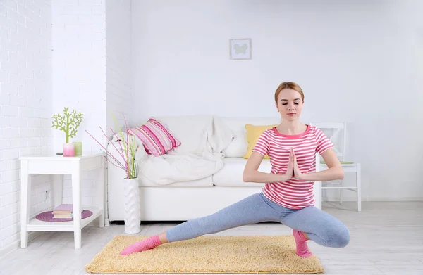 Mujer joven haciendo yoga en casa — Foto de Stock