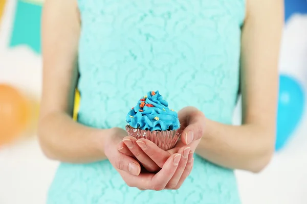 Close-up das mãos das mulheres segurando um bolo decorado com