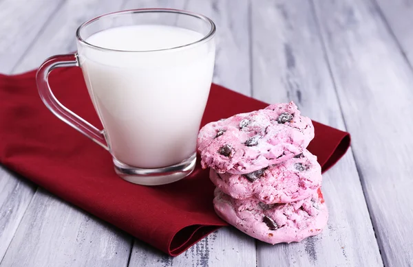 Pink cookies and cup with milk on table close-up — Stock Photo, Image