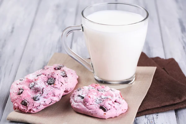 Biscoitos rosa e xícara com leite na mesa close-up — Fotografia de Stock
