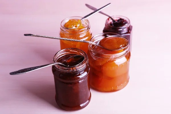 Sklenice chutné marmelády na dřevěné pozadí — Stock fotografie