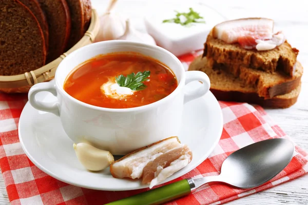 Oekraïense rode biet soep - Borsjt, op servet, op houten achtergrond — Stockfoto