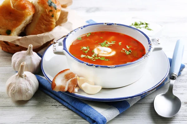 Ukrainian beetroot soup - borscht, on blue napkin, on wooden background — Stock Photo, Image