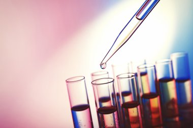 Pipet sıvı test tüpleri parlak arka plan üzerinde bir ekleme