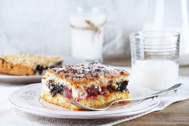 Reçel ve bir bardak süt ahşap masa ve hafif kumaş arka plan ile ev yapımı börek