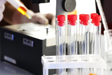 Yardımcısı el eldiven ile mikroskop beyaz arka plan üzerinde laboratuvarda analiz yapma