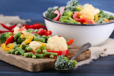 Peçeteye ahşap masa arka plan üzerinde kesme tahtası üzerinde Dondurulmuş sebzeler