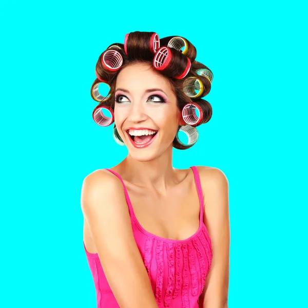 Menina bonita em encrespadores de cabelo no fundo azul — Fotografia de Stock