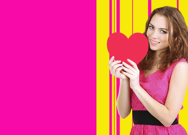 Beautiful young girl with heart on colorful background — Stock Photo, Image