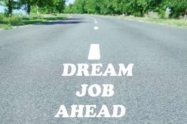 Text Dream Job Ahead marking on road surface