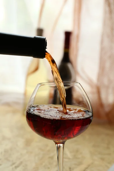 Red wine pouring into wine glass, close-up — Stock Photo, Image