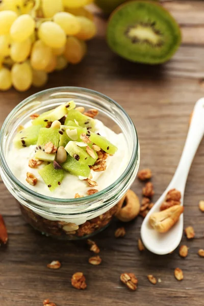 Postre en capas saludables con muesli y frutas en la mesa —  Fotos de Stock