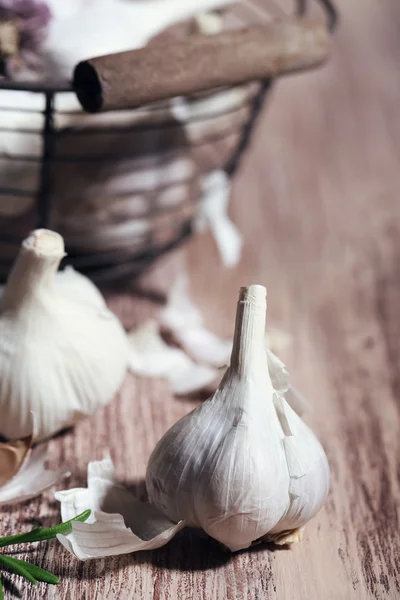 Rauwe knoflook en kruiden op houten tafel — Stockfoto