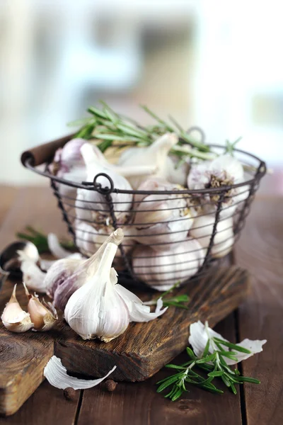 Rauwe knoflook en kruiden op houten tafel — Stockfoto