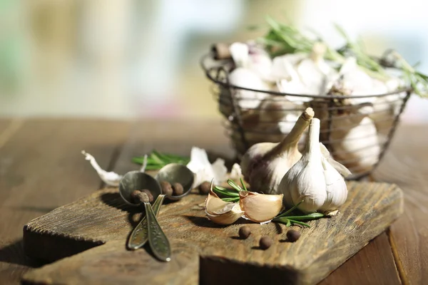 Rauwe knoflook en kruiden op houten tafel — Stockfoto