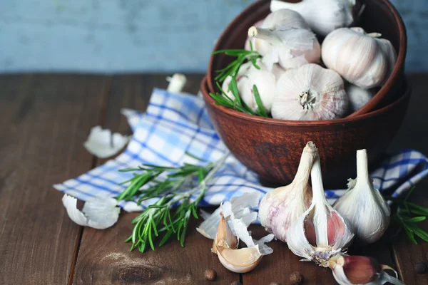 Rauwe knoflook en kruiden op houten tafel — Stockfoto