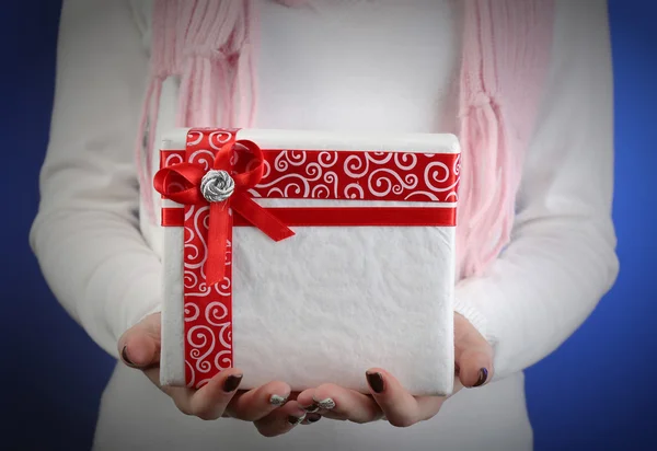 Geschenk box in vrouwelijke hand op kleur achtergrond — Stockfoto