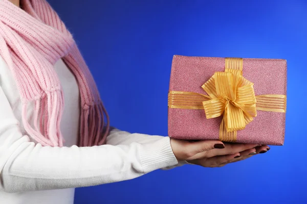 Geschenk box in vrouwelijke hand op kleur achtergrond — Stockfoto