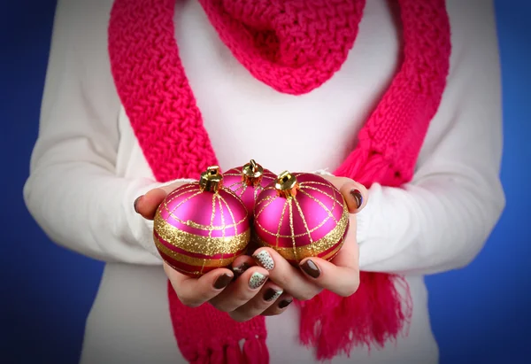 Рождественские украшения в женских руках на цветном фоне — стоковое фото