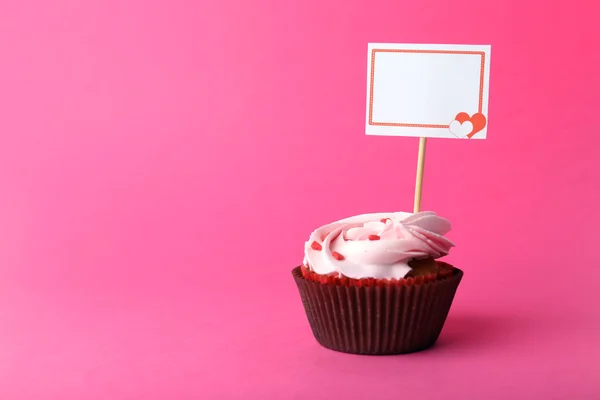 Вкусный кекс с надписью на розовом фоне — стоковое фото