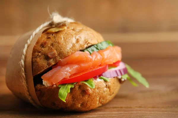 Sandwich con salmón sobre fondo de madera — Foto de Stock