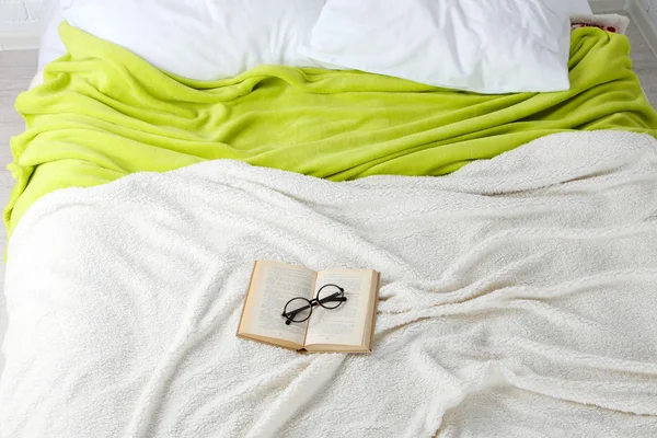 Buch und Brille im Bett in Großaufnahme — Stockfoto