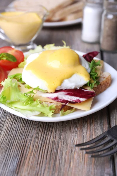 Torrada com ovo Benedict e tomate na placa na mesa de madeira — Fotografia de Stock