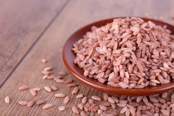 Roter Reis auf Teller auf Holzgrund — Stockfoto
