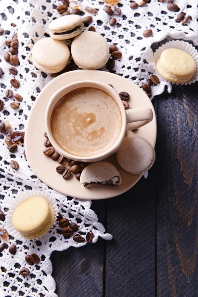 Macarrones coloridos suaves y café en taza sobre fondo de mesa de madera — Foto de Stock