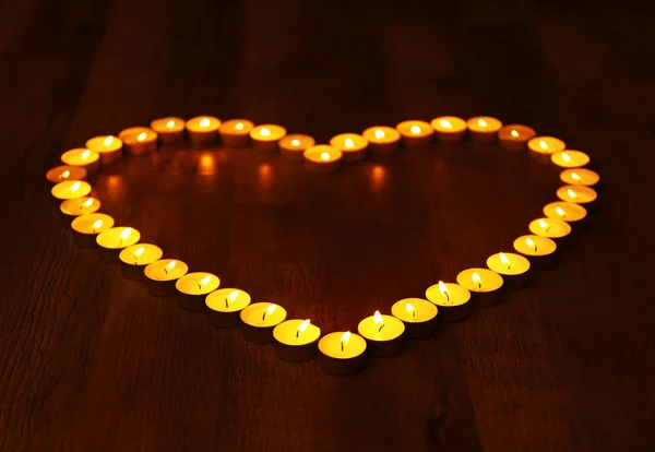 Burning candles in shape of heart on dark background — Stock Photo, Image