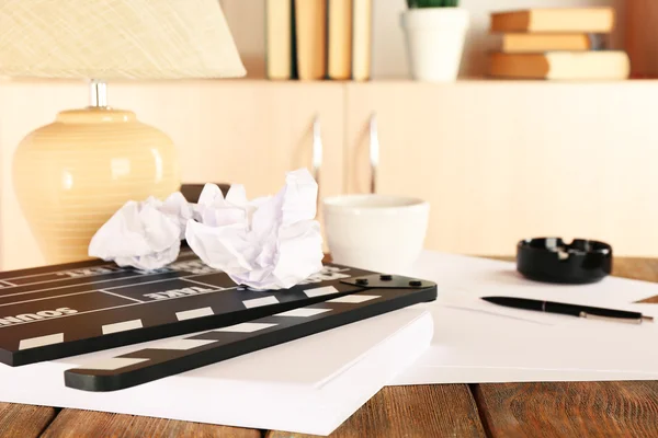 Desktop with moving clapper and working mess on light cupboard background — Stock Photo, Image