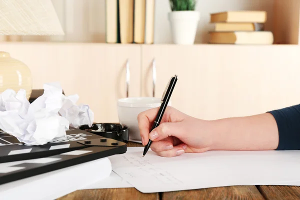 Clapper ve çalışma karışıklık hafif dolabın arka plan üzerinde Hareketli Masaüstü, kalem ile el — Stok fotoğraf