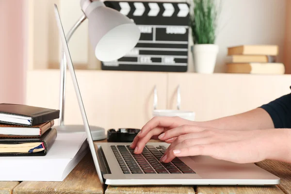 Vrouwelijke handen van scenarioschrijver bezig met laptop aan balie op kast achtergrond — Stockfoto