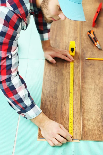 Carpenter worker installing laminate flooring in the room — Stock Photo, Image