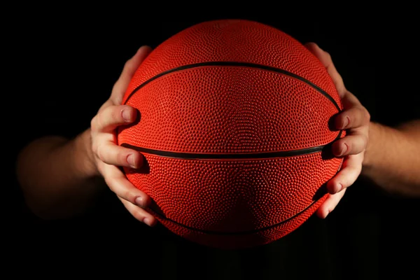 Basketball player holding ball, on dark background — Stock Photo, Image