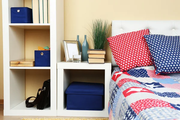 Interior de quarto colorido moderno com cama e mesa de cabeceira, com detalhes de design no fundo da parede de luz — Fotografia de Stock