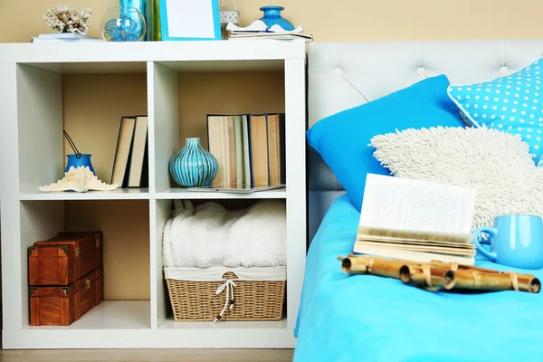 Modern colorful bedroom interior with bed and nightstand, with design details on light wall background — Stock Photo, Image