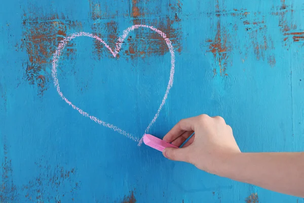 Mano dibuja corazón de tiza en tablero de madera — Foto de Stock