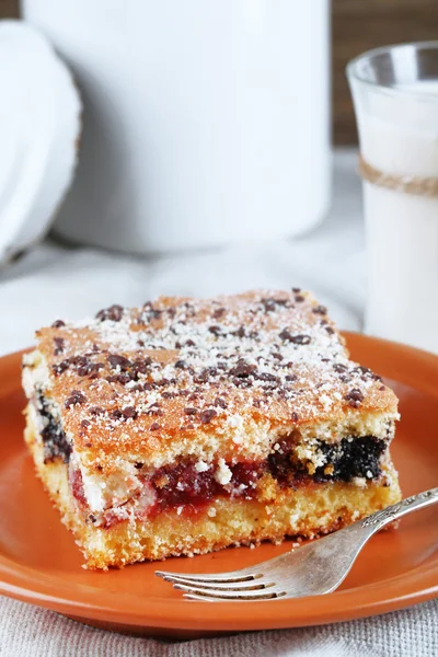 Homemade pie with jam and glass of milk on tablecloth background — Stock Photo, Image