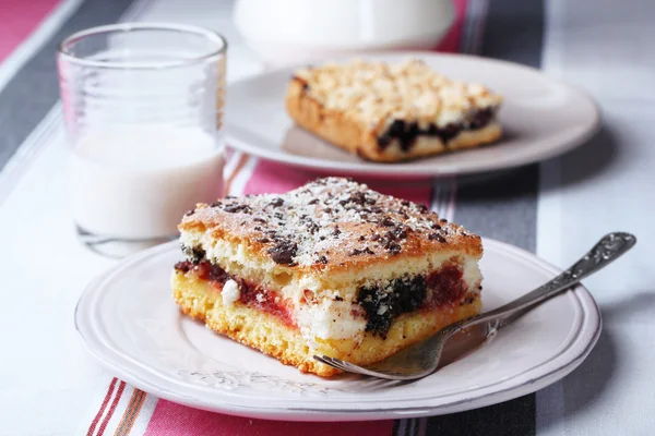 Homemade pies with jam and glass of milk on striped tablecloth background — Stock Photo, Image