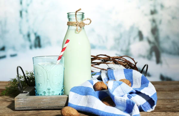 Färsk mjölk med naturlig inredning, på träbord, på vintern bakgrund — Stockfoto