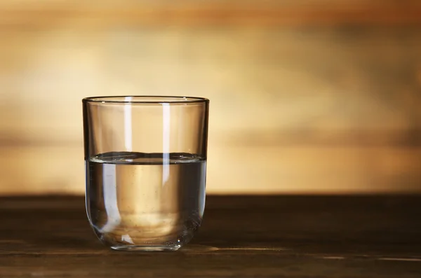 Vaso de agua mineral limpia sobre fondo rústico de madera — Foto de Stock