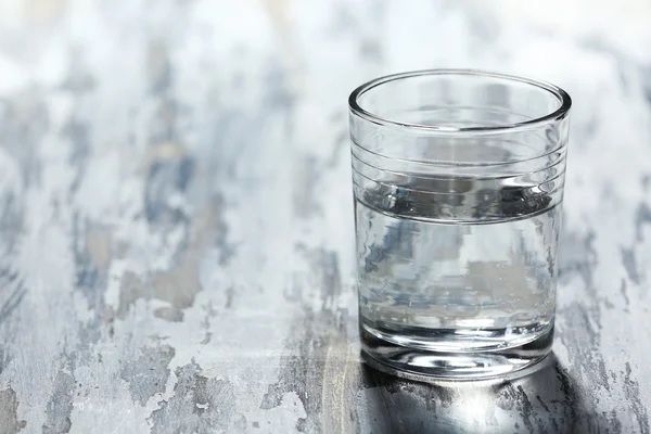 Glas schoon mineraalwater op oude houten achtergrondkleur — Stockfoto