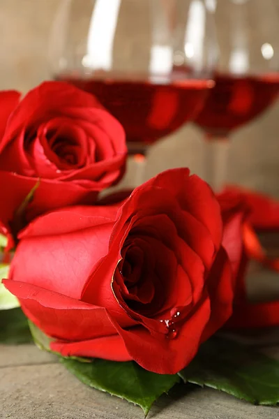 Composición con vino tinto en copas, rosas rojas y corazón decorativo sobre fondo de madera —  Fotos de Stock